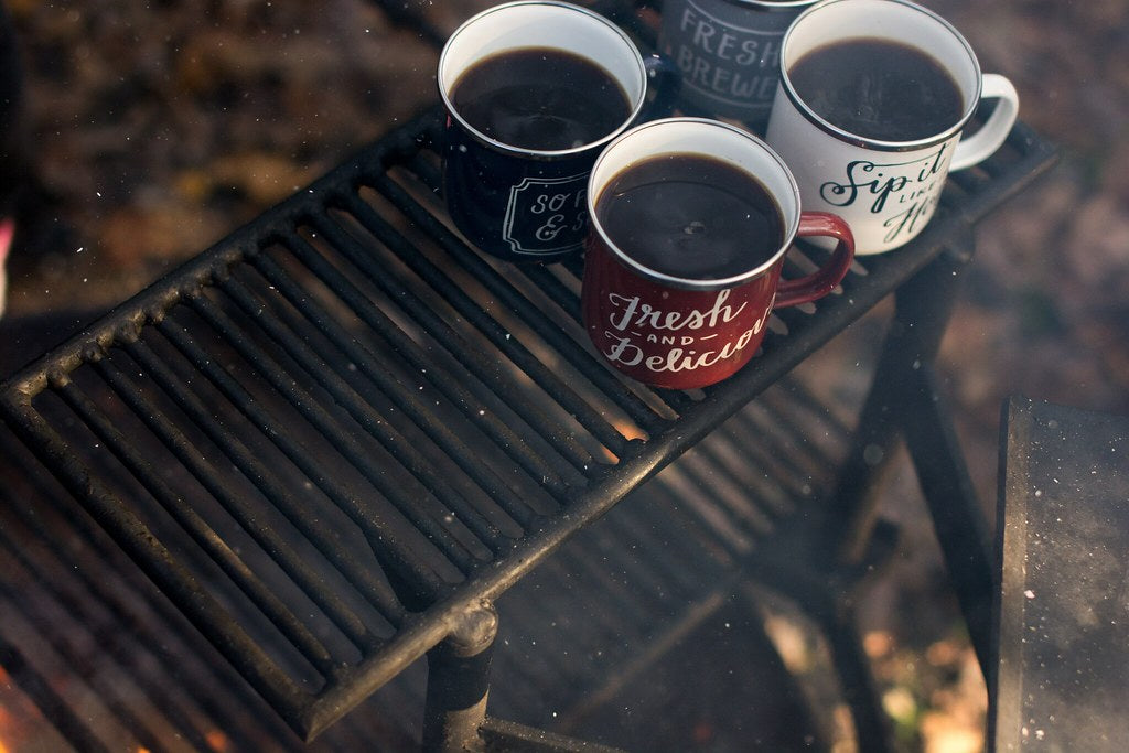 four assorted-color ceramic mugs on black grill frame - Credit to https://myfriendscoffee.com/